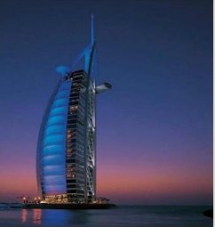 Kontraste: Das Burj al Arab in Dubai und ein Moscheeturm im Sonnenuntergang